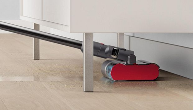 The Dyson Submarine wet roller head cleans under a low cabinet.