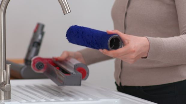 The Dyson submarine wet roller head is cleaned in a kitchen sink.