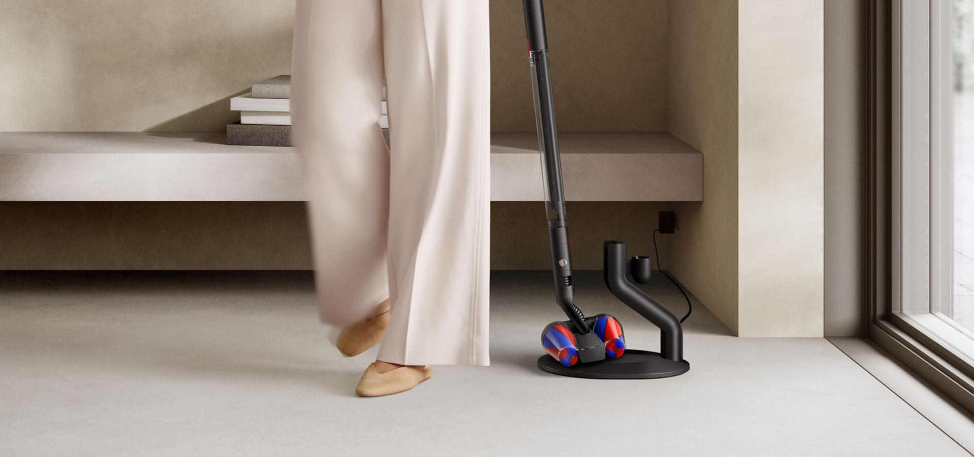 다이슨 PencilVac™ 펜슬백 청소기를 충전 거치대에 놓는 모습