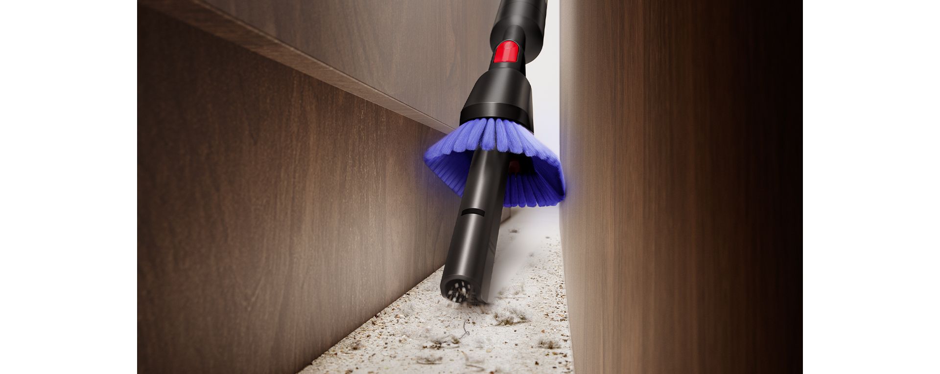 The Dyson PencilVac cleaner being used with the Combi crevice tool to cleana crevice low down