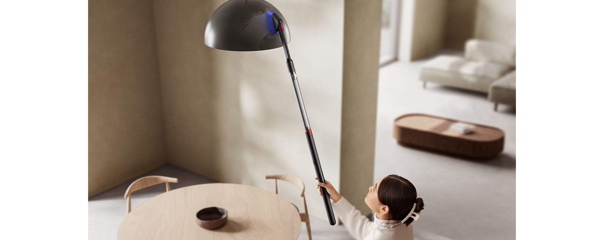 The Dyson PencilVac cleaner being used with the Combi crevice tool to clean a lightshade high up