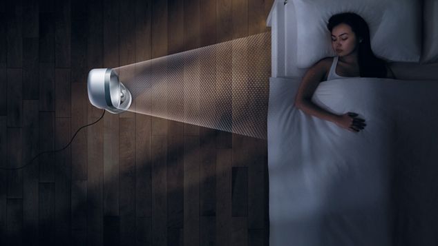 A imagem mostra uma mulher deitada na cama enquanto Dyson Pure Cool Link purifica o ar em seu redor.
