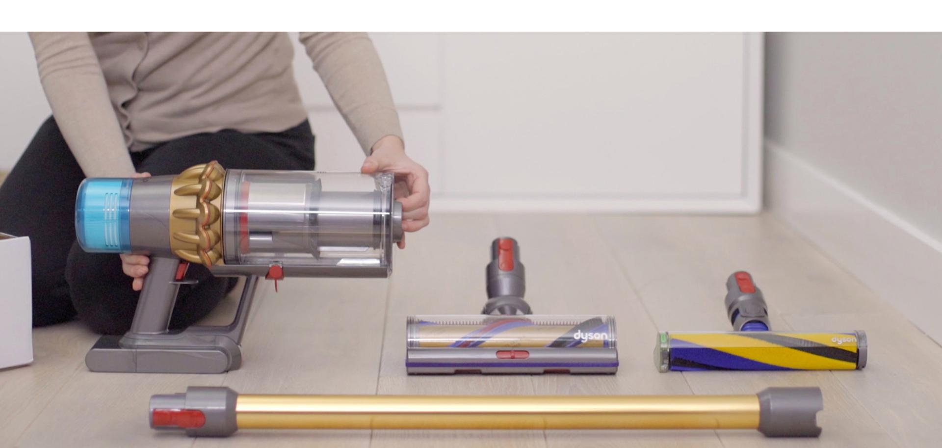 Someone holding the Dyson V15 Detect vacuum on the floor.