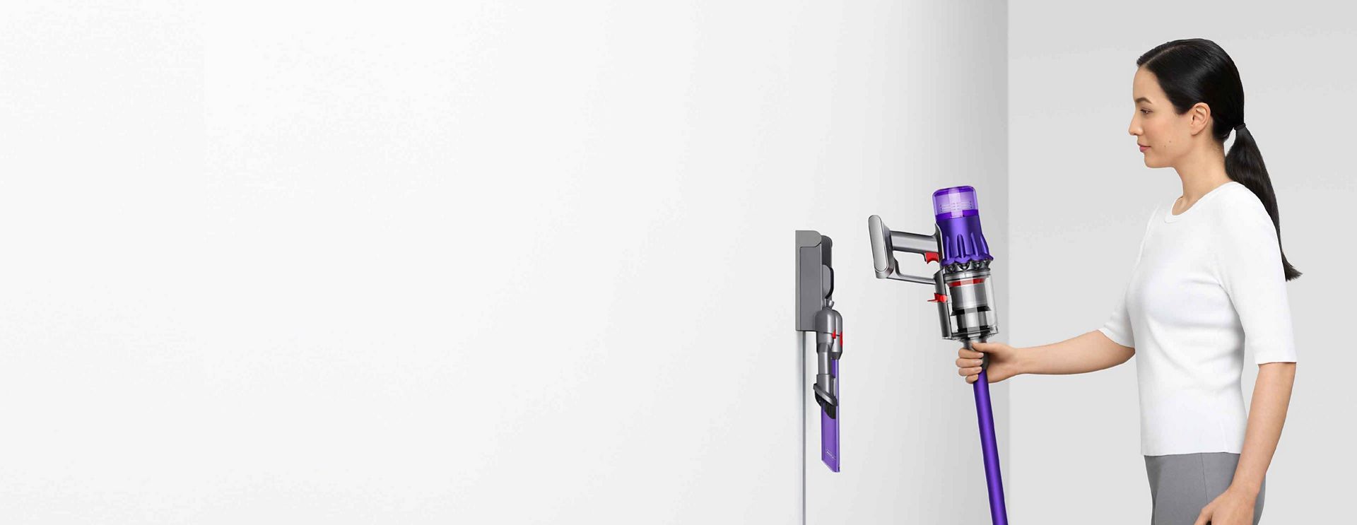 ウォールドックから掃除機を外す女性