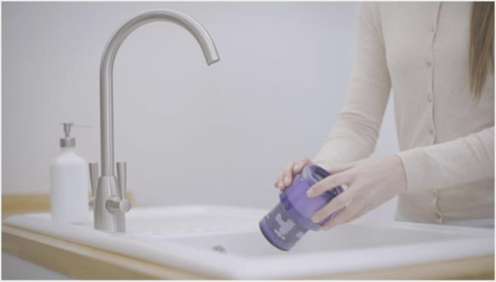 O femeie spălând filtrul aspiratorului Dyson V11™ 