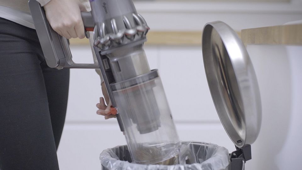 Dyson V11™ bin being emptied into waste bin