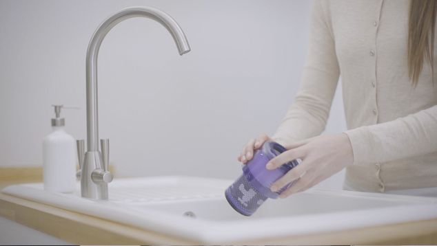 Filtro do Dyson V11™ a ser segurado sobre um lavatório