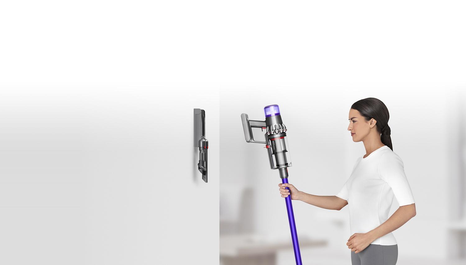 Woman placing Dyson V11™ vacuum into wall charging dock