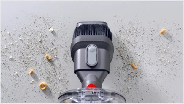 Accesoriul pentru spații înguste Dyson V11™ curățând spațiile înguste de pe canapea