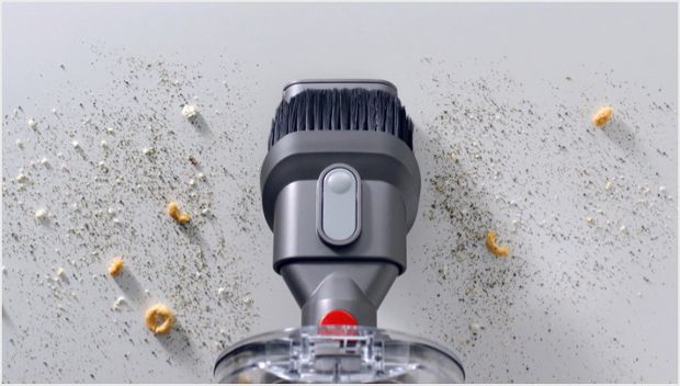 Accesoriul pentru spații înguste Dyson V11™ curățând spațiile înguste de pe canapea 