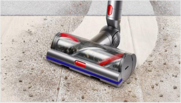 Capul de curățare High Torque Dyson V11™ trecând de pe pardoseală dură pe covor