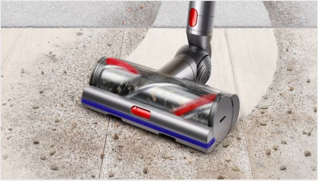Capul de curățare High Torque Dyson V11™ trecând de pe pardoseală dură pe covor