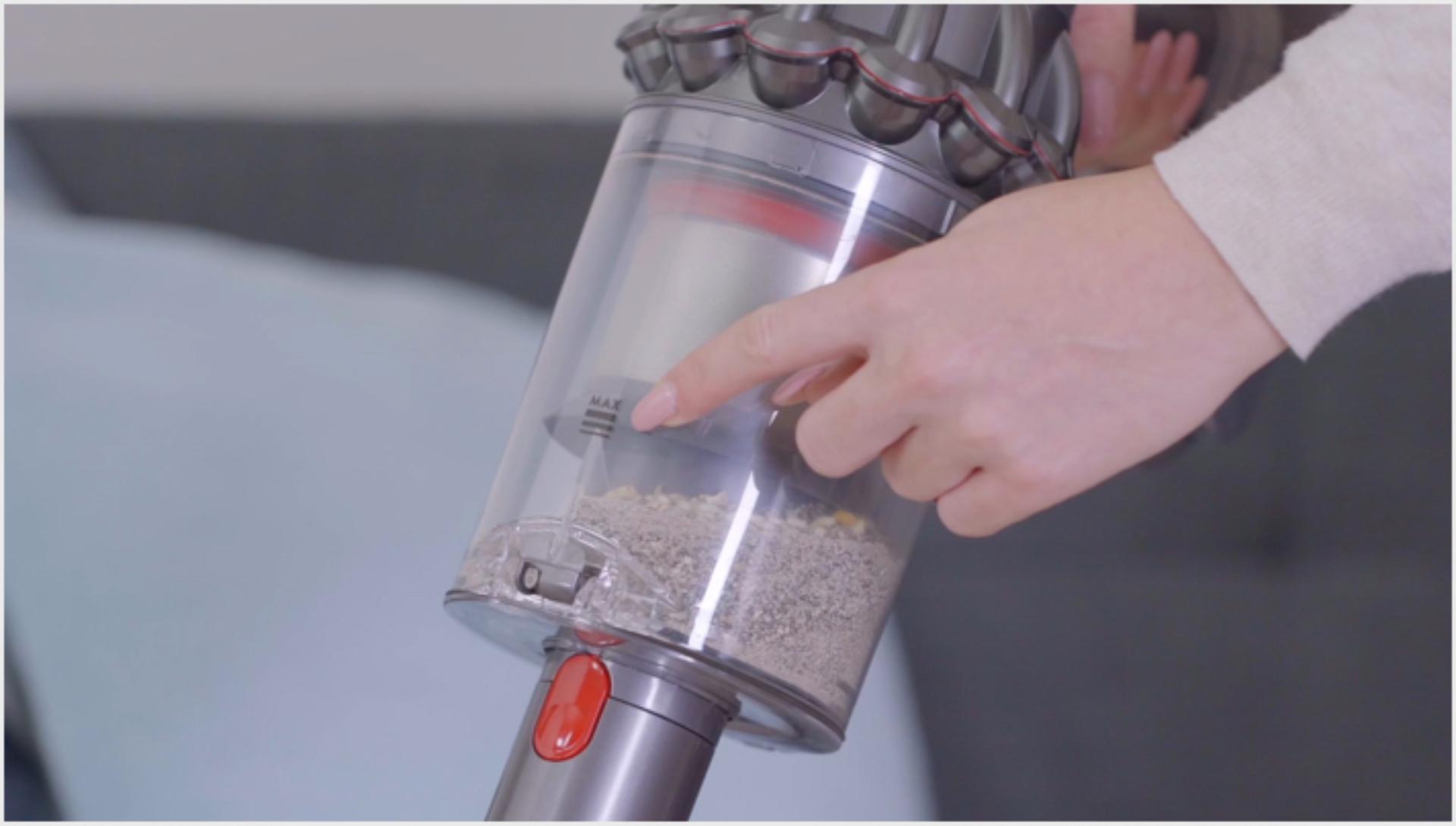 Người phụ nữ đang chỉ vào dấu MAX trên ống rác Dyson V11™