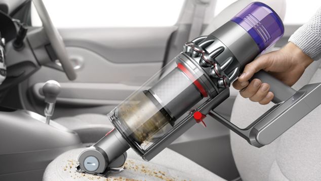 Man vacuuming crumbs from a baby's car seat using the Combination tool