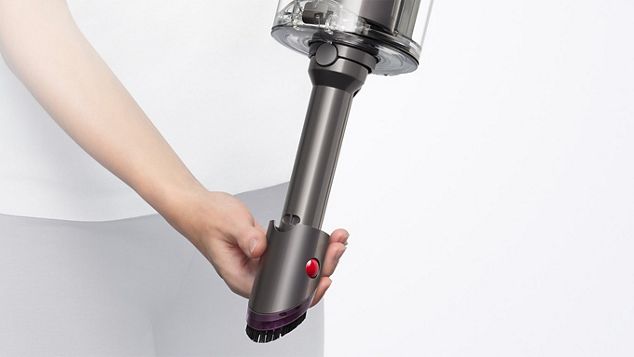 User detaching the wand to use the Built-in dusting and crevice tool.
