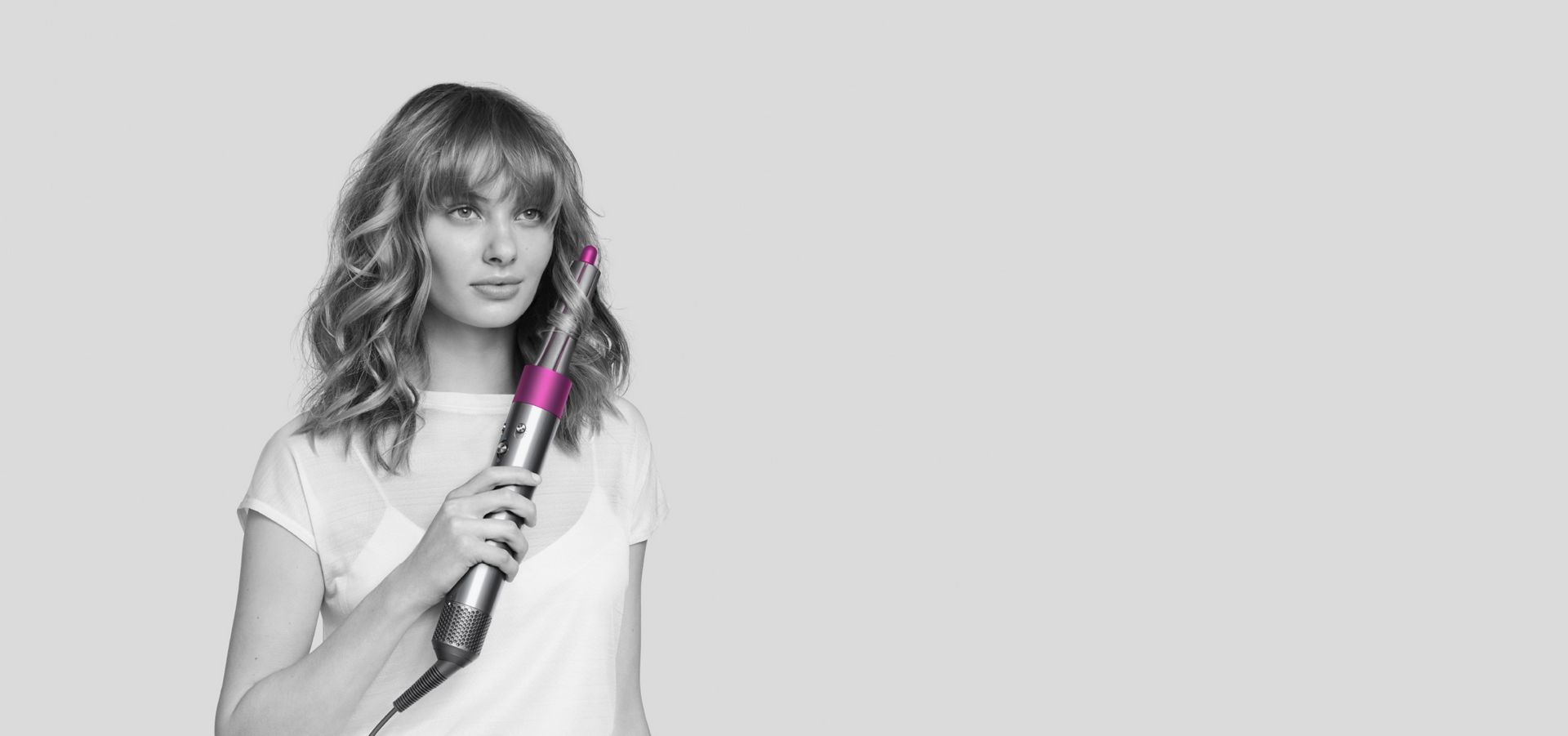 Woman curling hair with Dyson Airwrap™ styler.