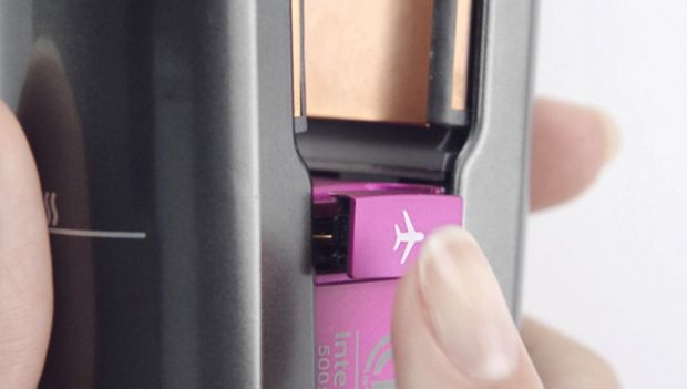 Thumb over Flight-ready tag, which is a pink removable tag with a plane icon on it.