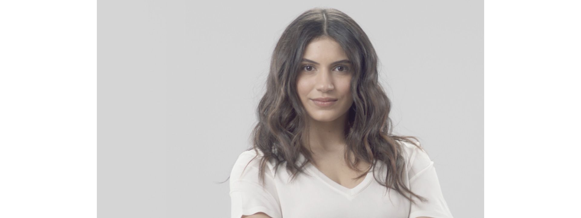 Lady with dark, wavy, smooth hair.