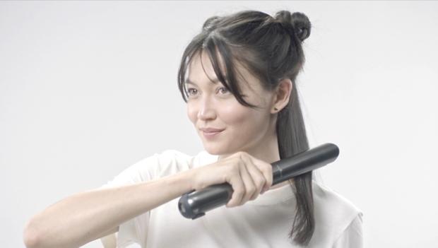 Naine juukseid sirgendamas