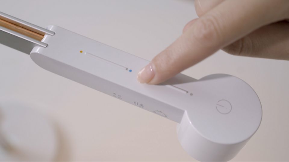 Uma pessoa a ajustar o candeeiro de trabalho Dyson Lightcycle™