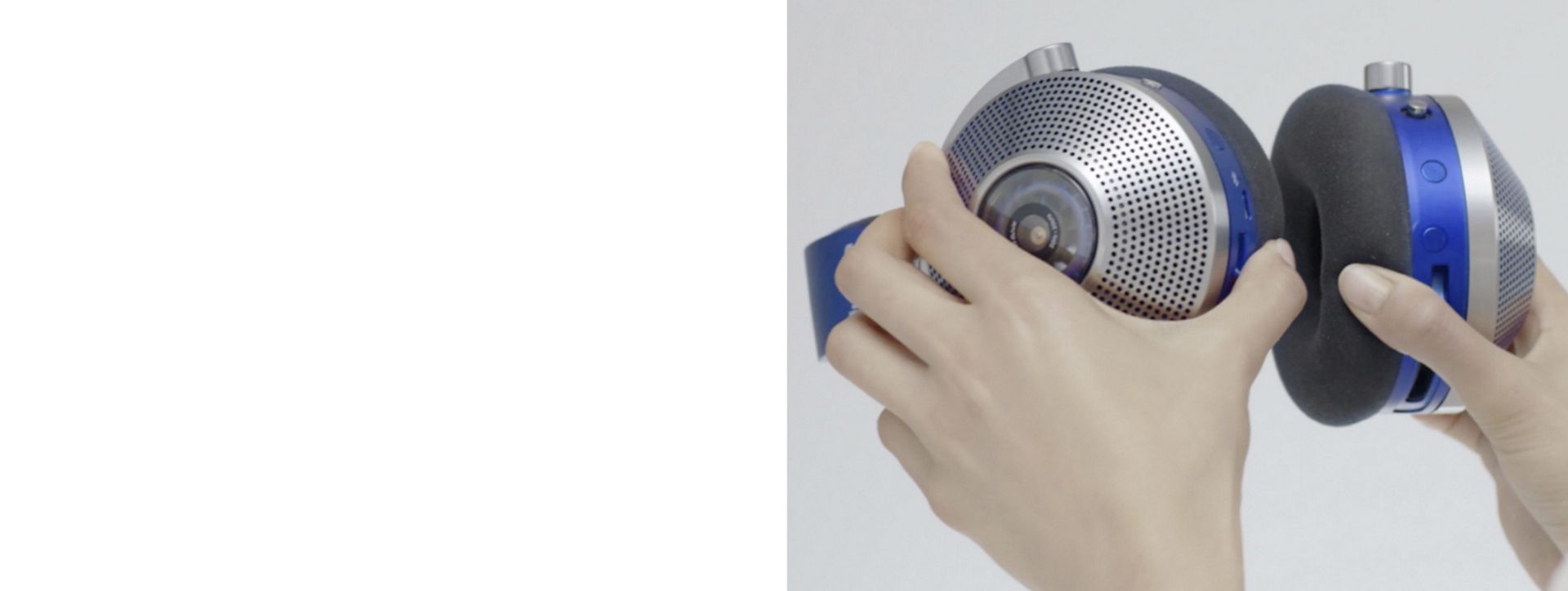 Hands holding the ear cups of the Dyson Zone headphones. 