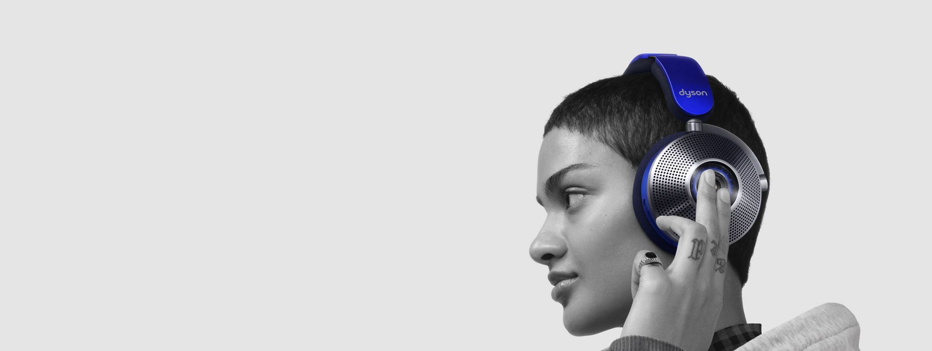 Woman taps the side of the ear cup to change ANC mode.