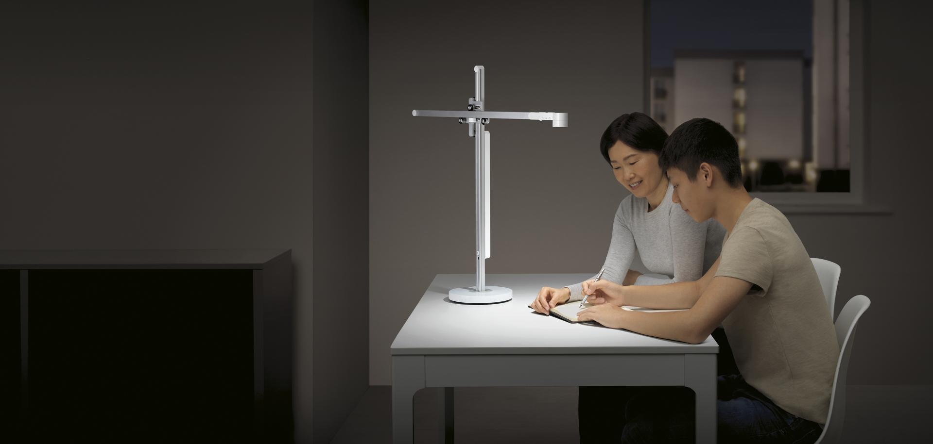 Mamá y su hijo adolescente estudiando bajo la lámpara de trabajo Dyson Lightcycle