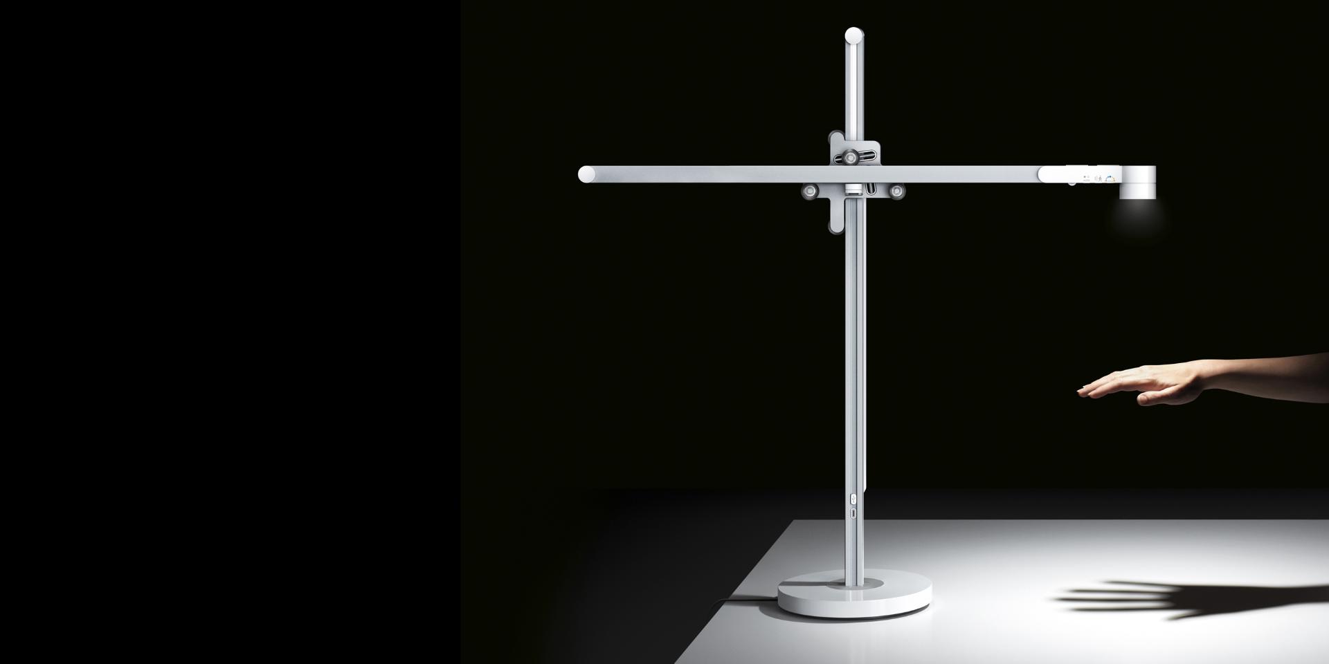 La lámpara de trabajo Dyson Lightcycle brillando con potencia en una mano