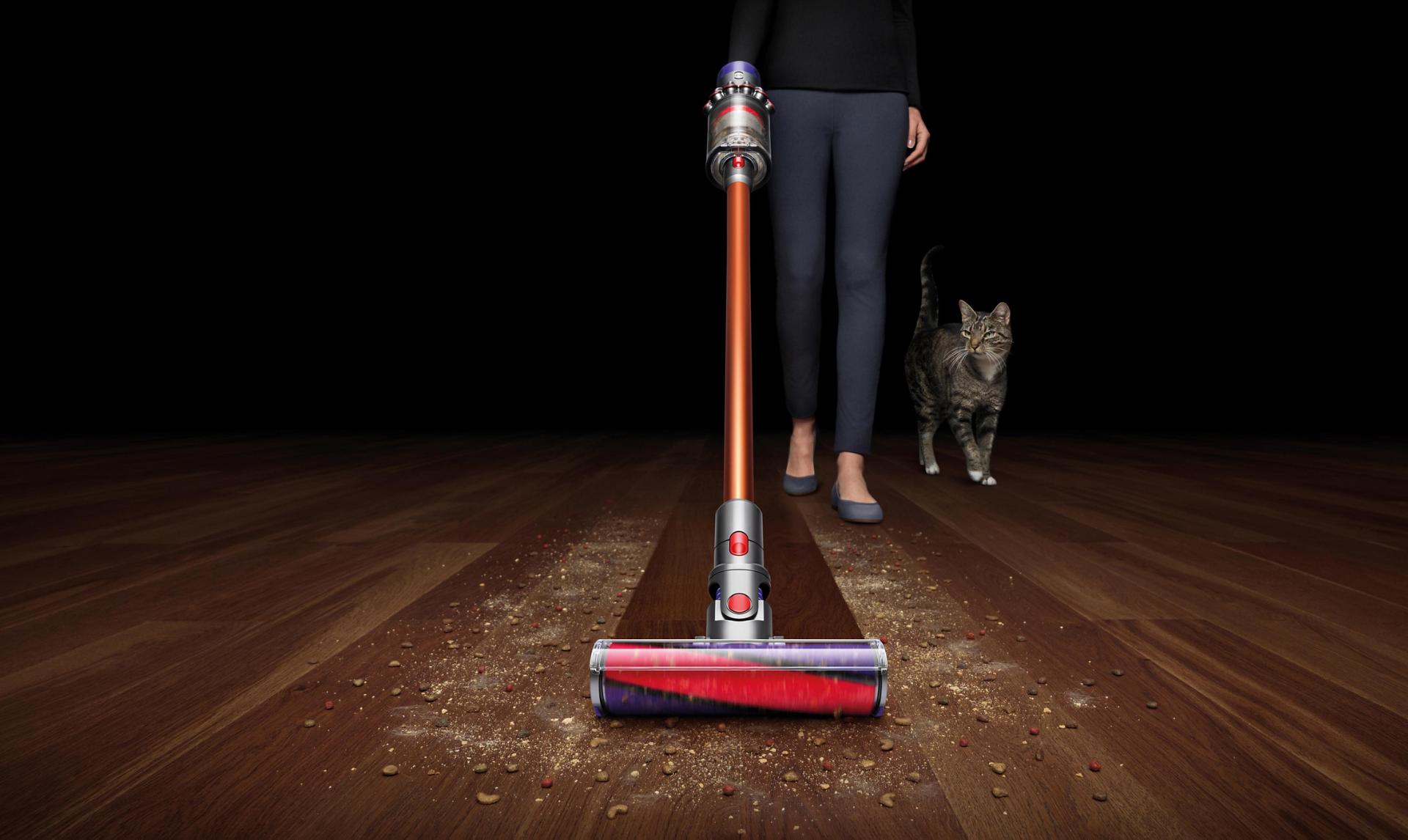 Women vacuuming with cat following