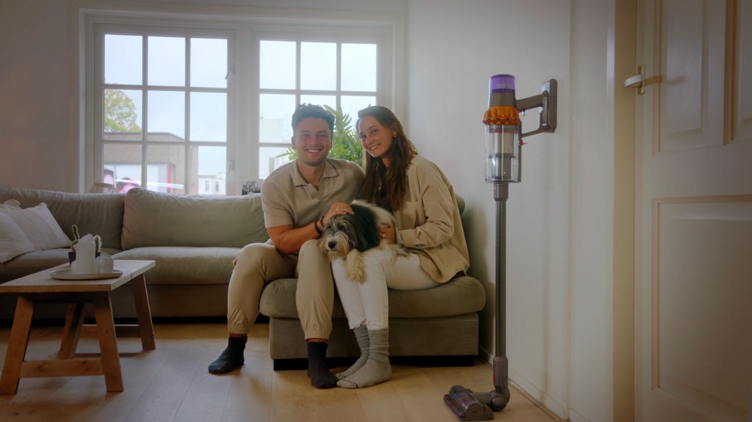 Couple heureux avec aspirateur et chien