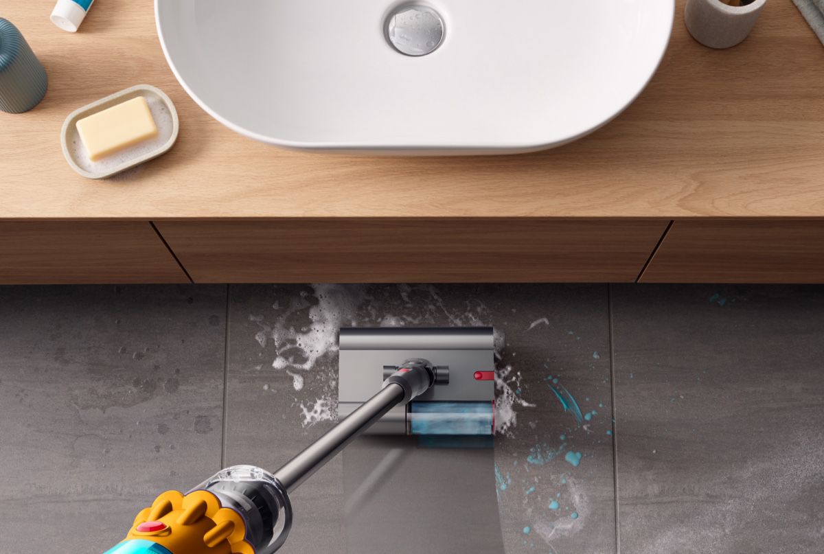 Le Dyson V15s Detect Submarine en train de laver de la saleté sur un sol dur noir