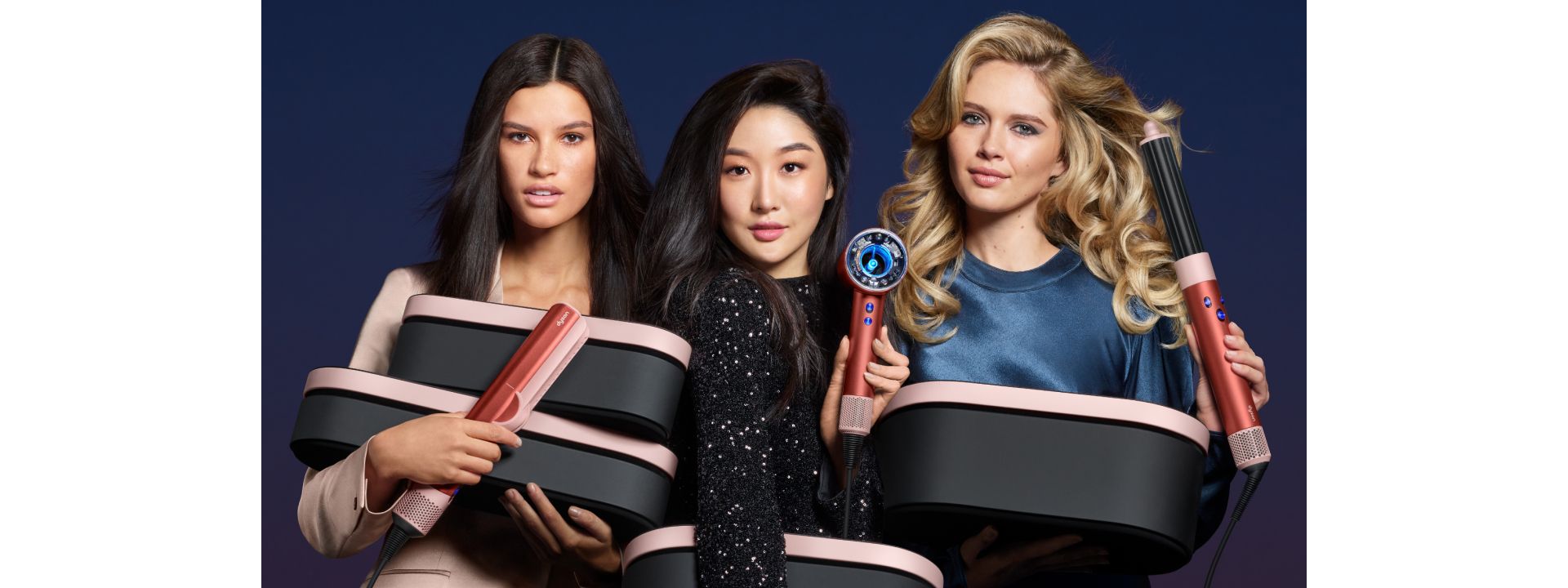 Trzy modelki z limitowaną edycją prezentową urządzeń do stylizacji włosów Dyson w kolorze Truskawkowy Brąz