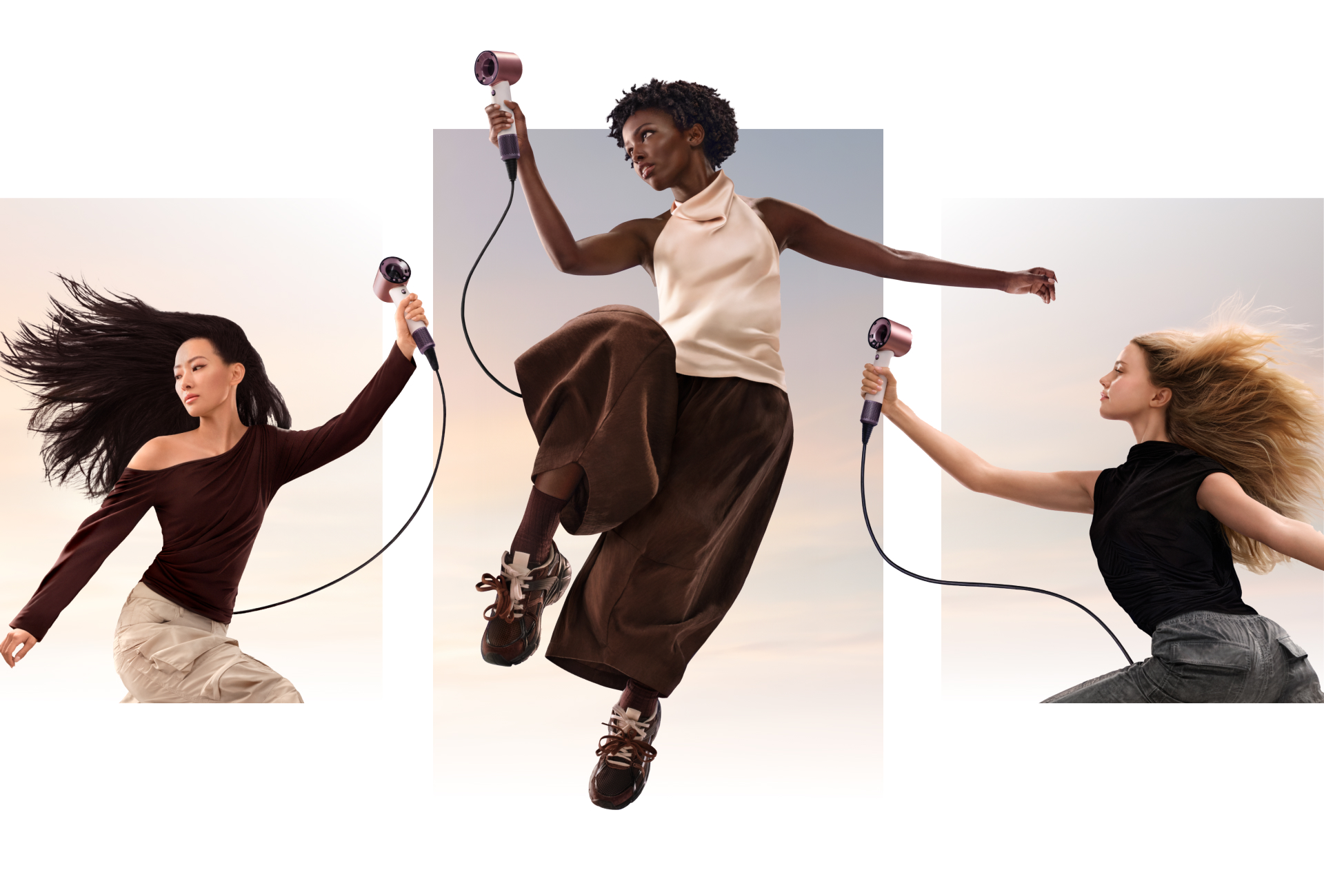 A group of jumping models in mid-air holding the Dyson Supersonic Travel hair dryer.