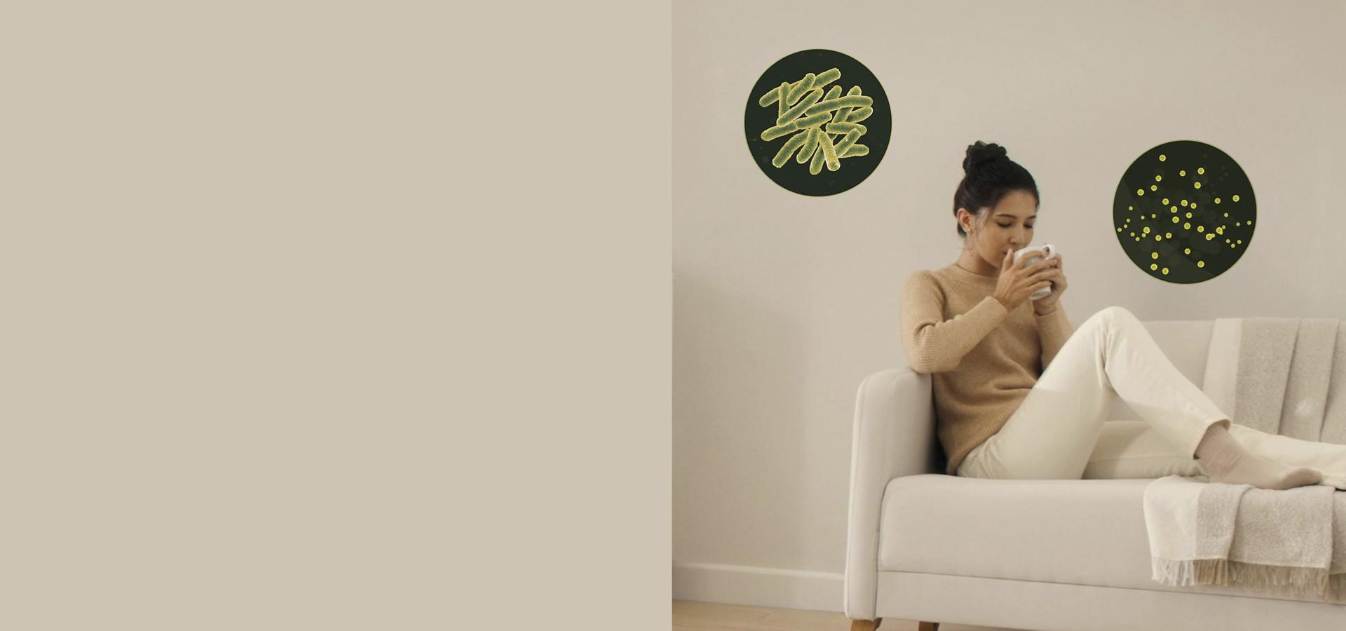 Kanepede etrafını ultra ince partiküller tarafından çevrelenen bir kadın.