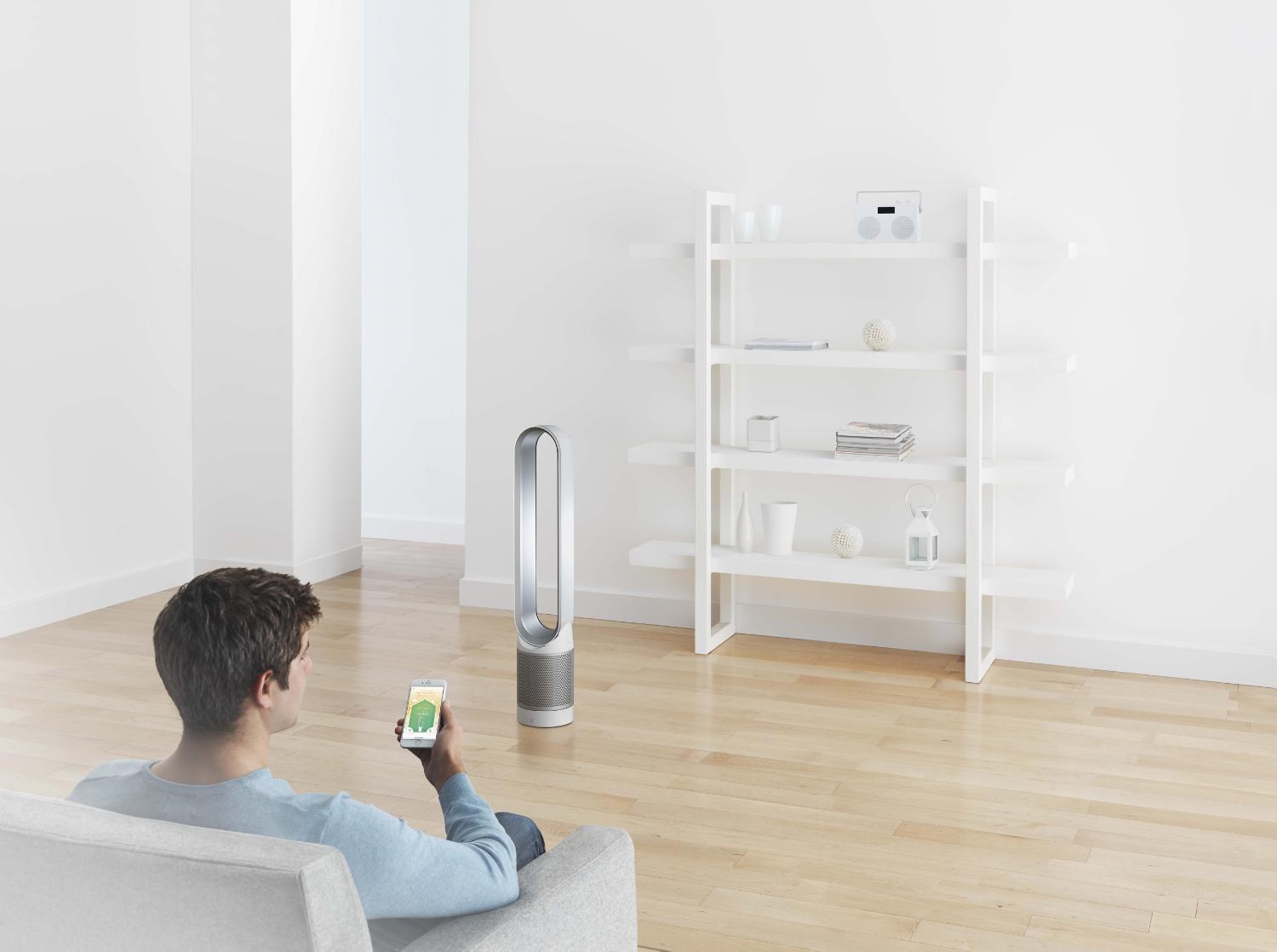 Man with smartphone and Dyson Pure Cool™ Link tower purifier