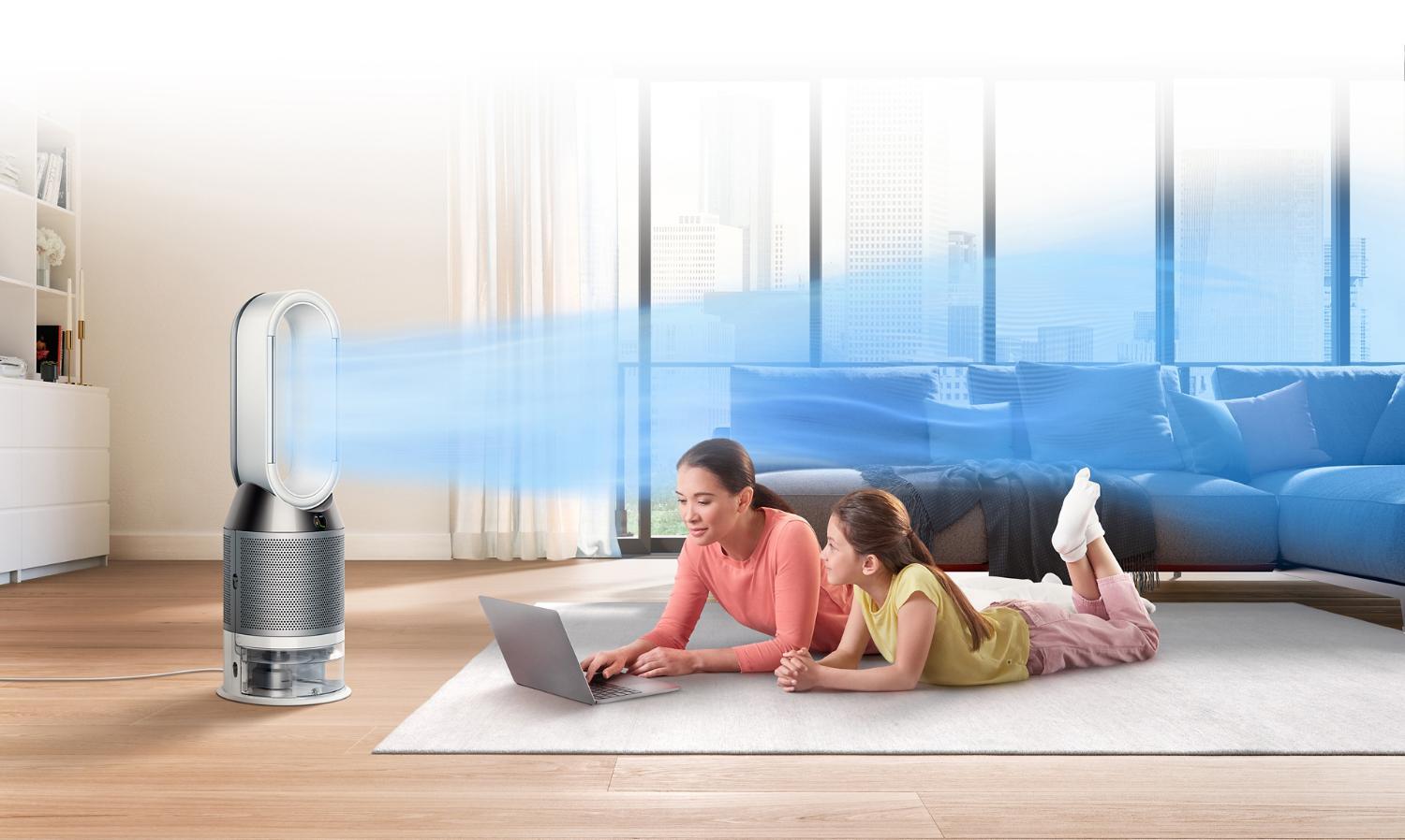 En mor og datter bliver afkølet af ventilatoren på en varm dag