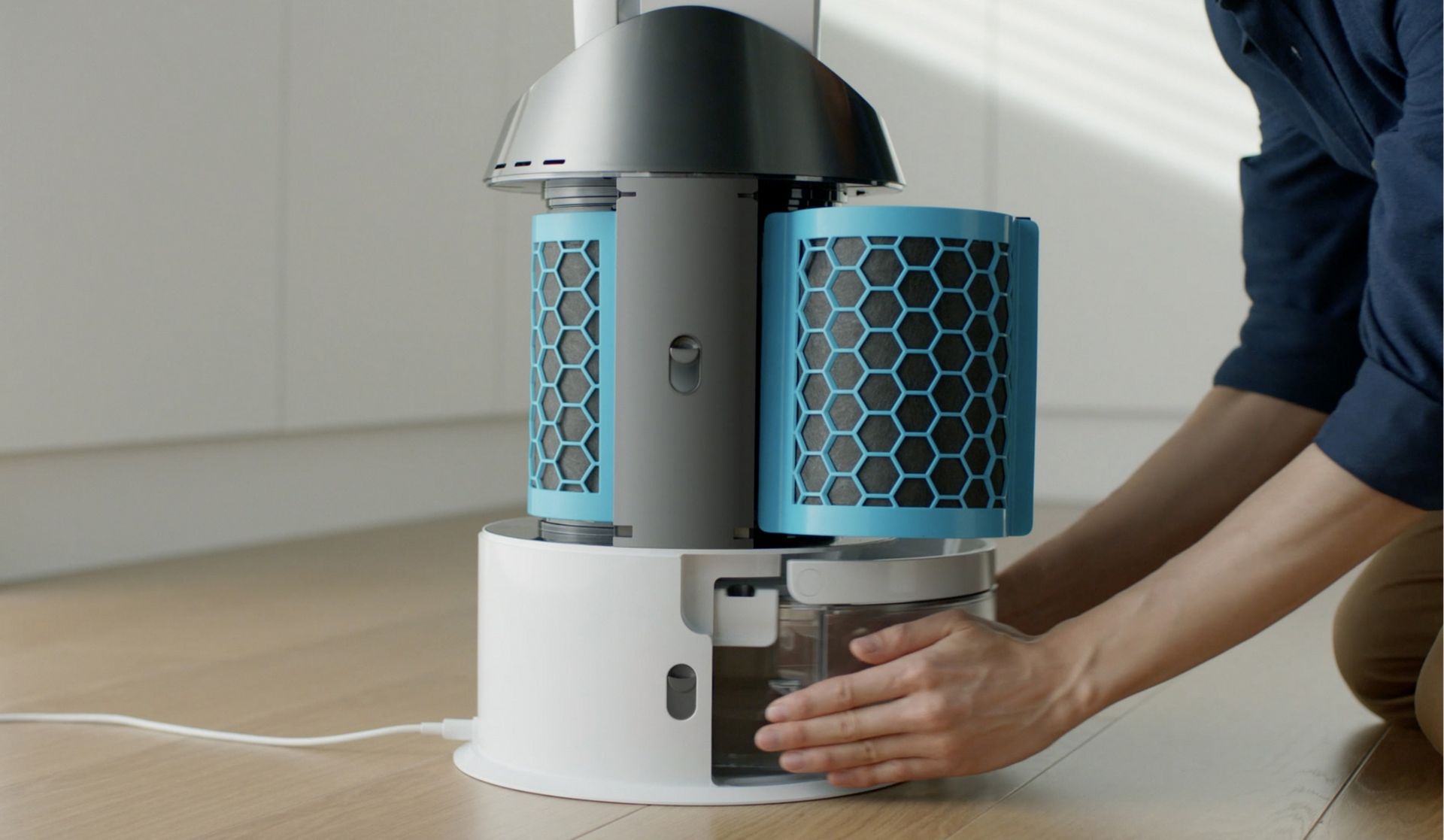 A person performing maintenance on their purifier, with clickable play button to show Deep clean cycle film.