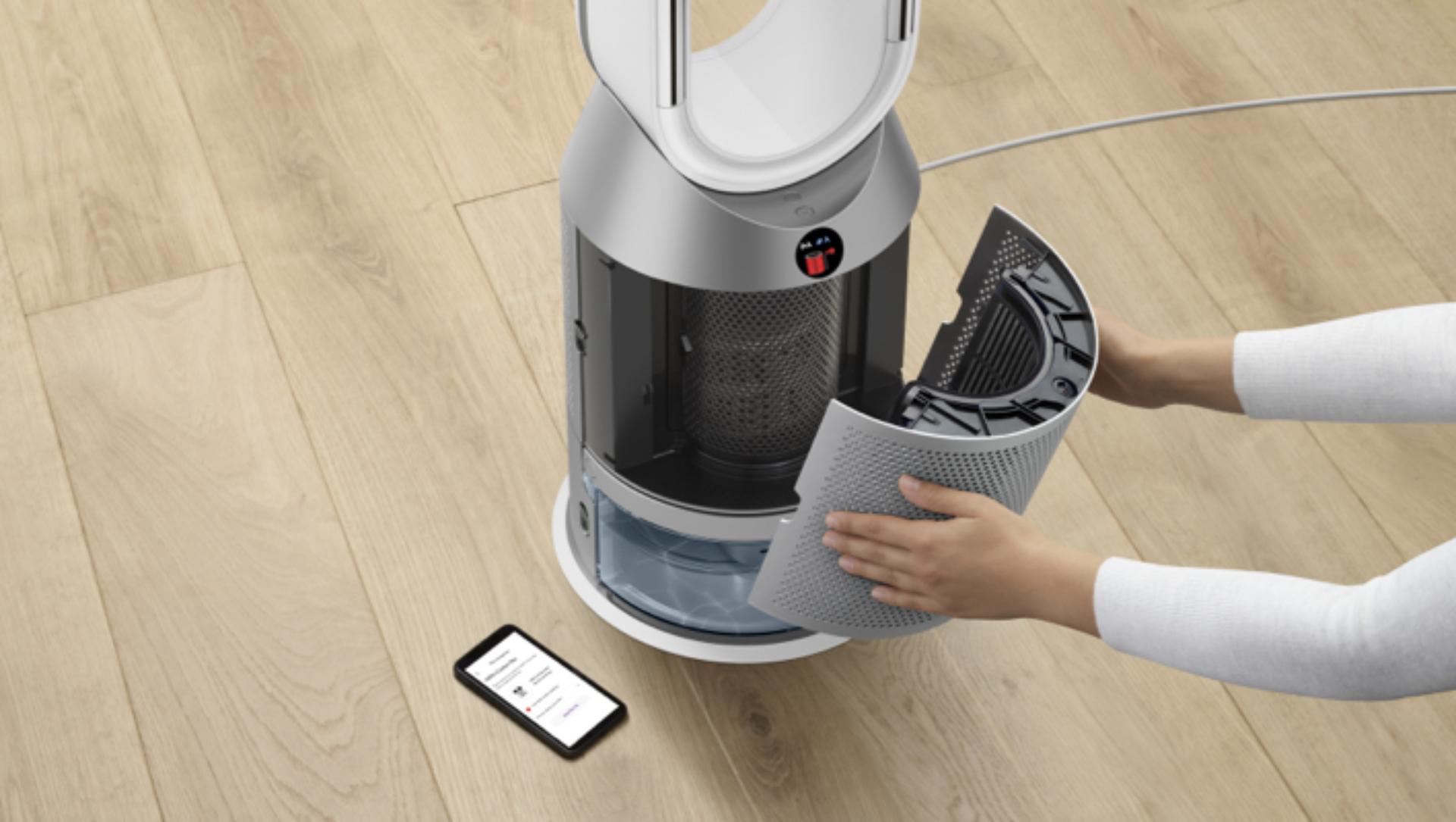 Una mujer quita un filtro del purificador y humidificador Dyson