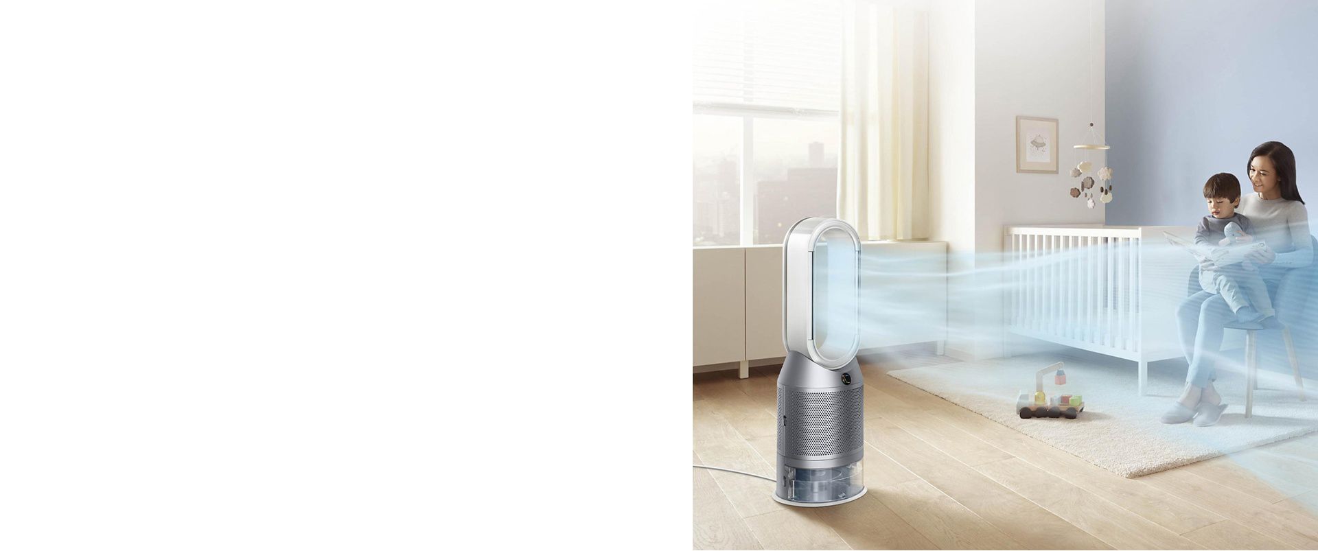  清浄した空気を本を読む母子に送るDyson Purifier Humidify+Cool 加湿空気清浄機 ホワイト/シルバー。 背後の乳児用ベッド。 