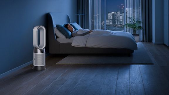 Der Dyson Purifier Cool PC1 Luftreiniger arbeitet im Nachtmodus neben einer schlafenden Person.