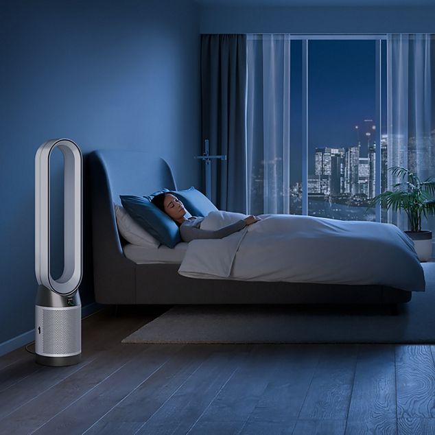 A Dyson purifier in a bedroom, purifying air at night while a person sleeps