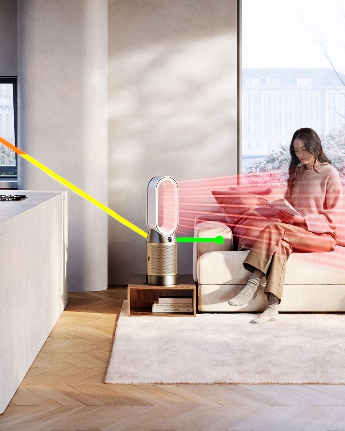 A living space with a person cooking and a person sitting on a sofa reading. A Dyson purifying heater is purifying the air.