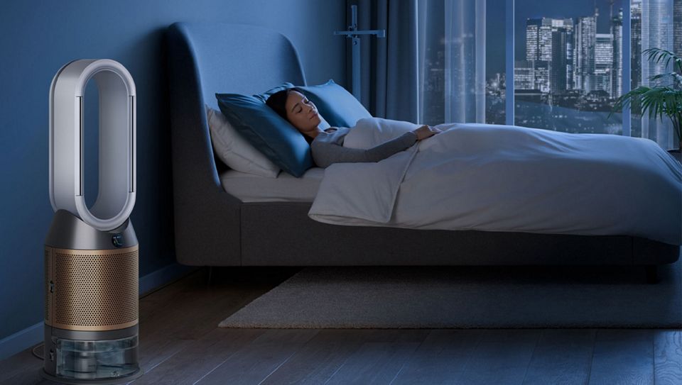 A purifier humidfier in a bedroom, purifying and hydrating air at night while a person sleeps