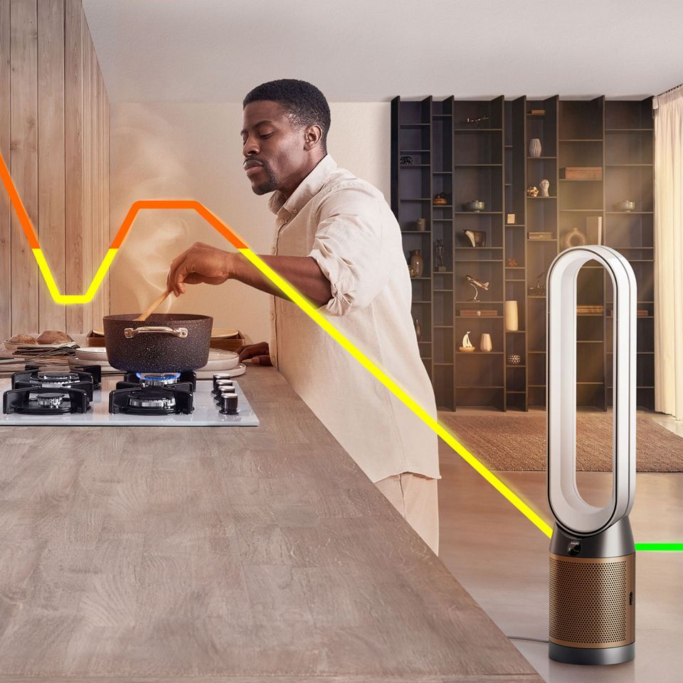 Una persona che cucina mentre un dispositivo Dyson purifica l'aria