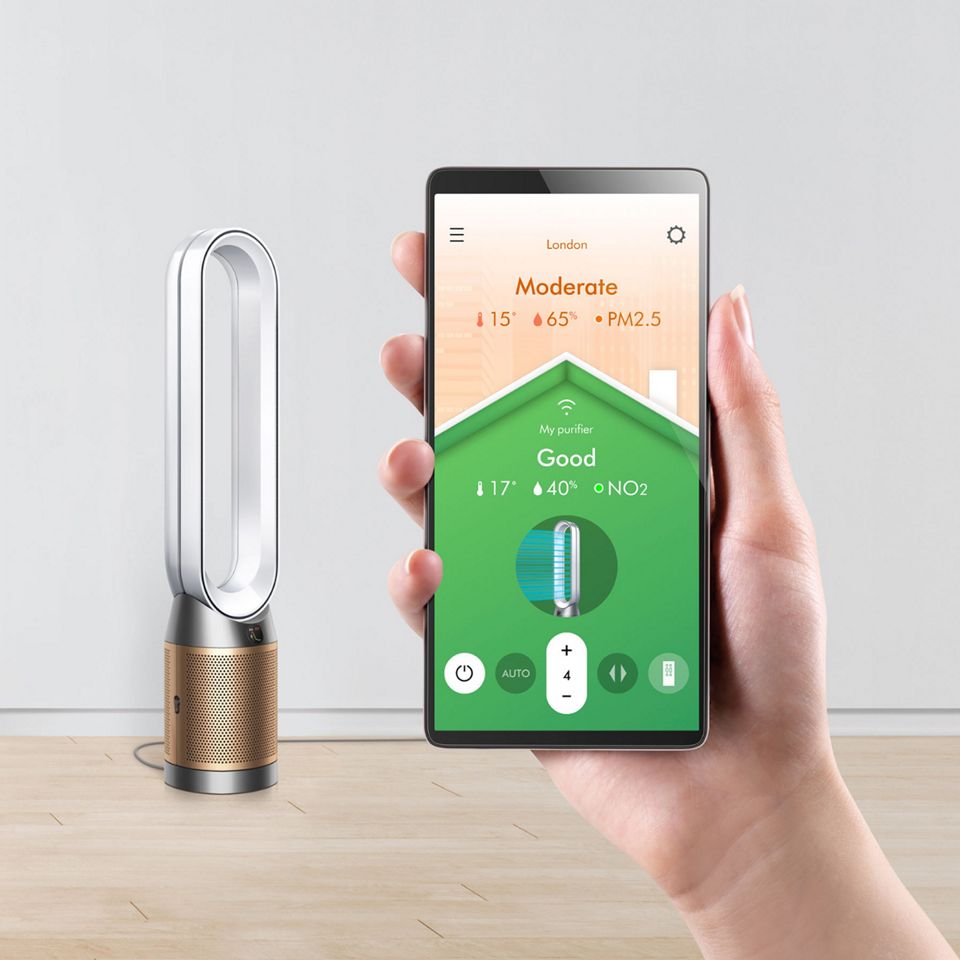 Una persona mentre usa l'app sul proprio telefono con un purificatore sullo sfondo