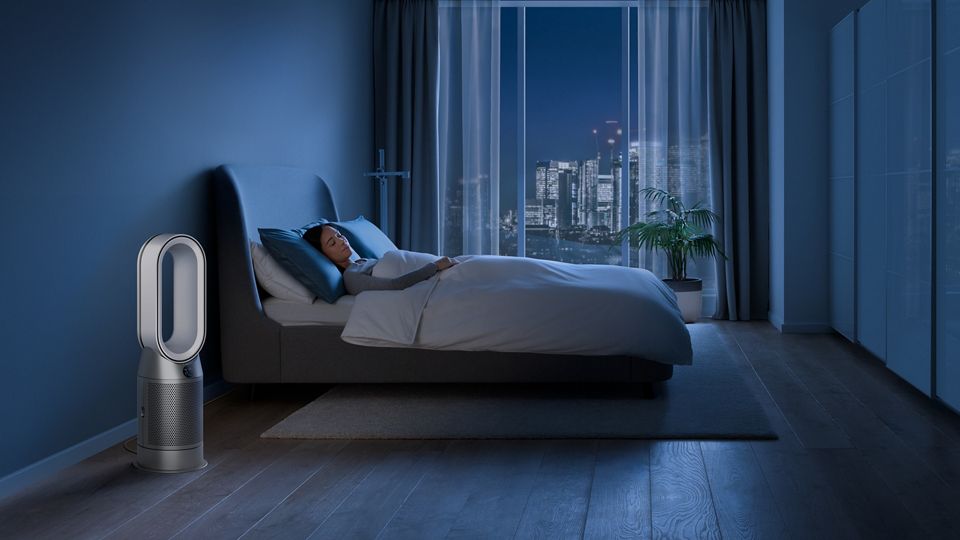 Woman in bed beside Dyson Purifier fan