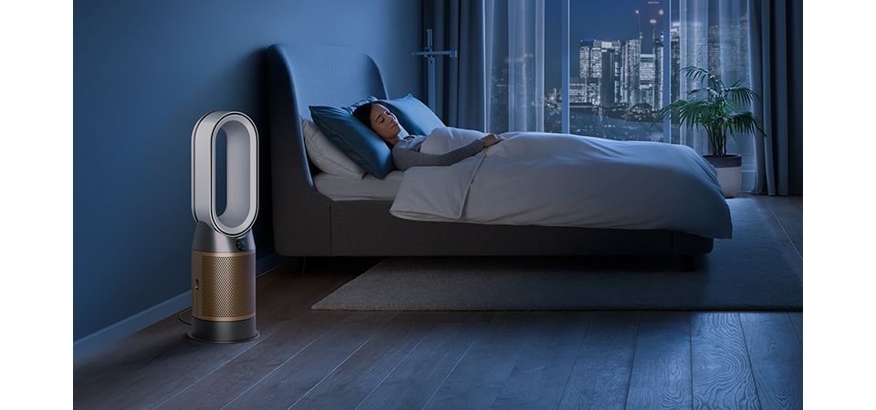 Een Dyson luchtreiniger in een slaapkamer 's nachts.