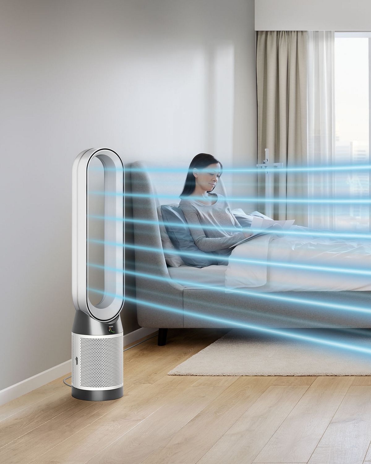 A woman sits on the sofa in a city apartment. A stream of blue, illustrating cool, purified air, projected from the Dyson Cool purifier fan onto her. 