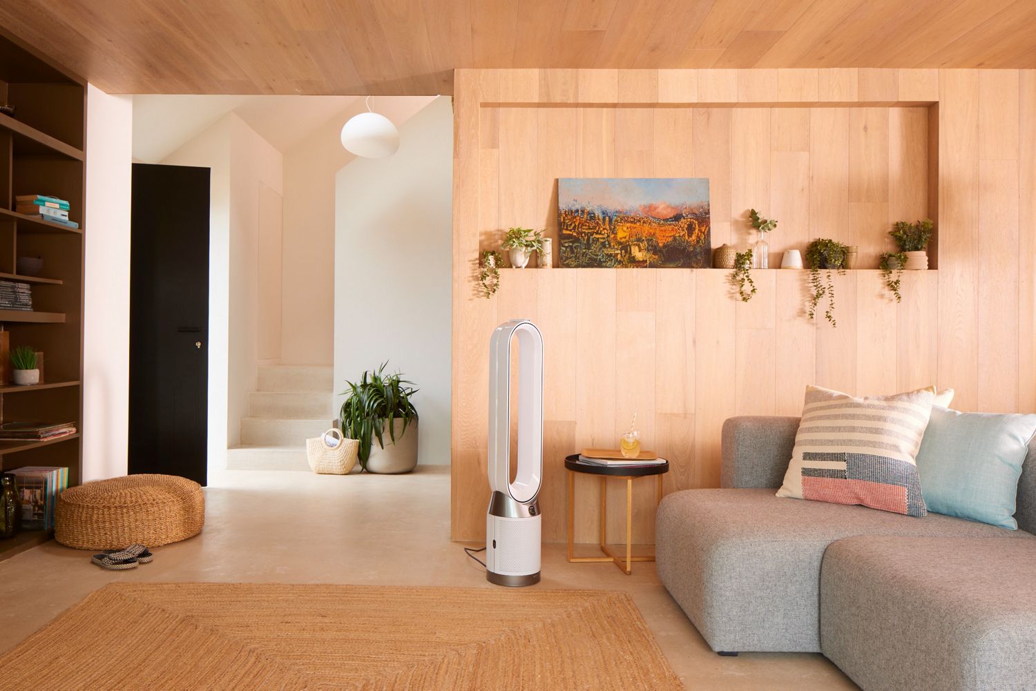 A woman lies in bed at night with a Dyson Pure Cool  purifier projecting a stream of purified air onto her. 