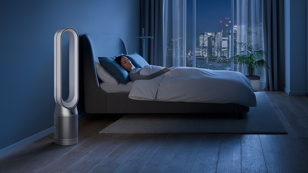 Dyson purifier in a dark bedroom with someone sleeping peacefully